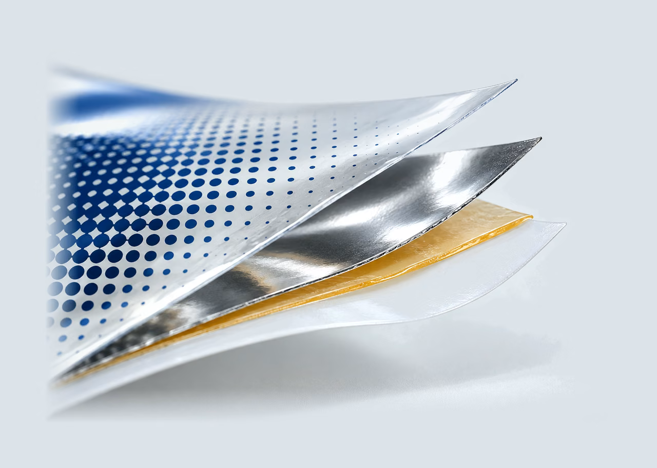 Illustration: a laminate peeled into four layers: printed outer film, metallised layer, adhesive and sealant film
